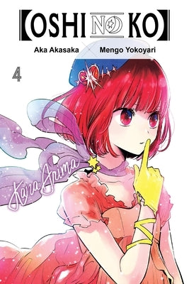 Paperback copy of Oshi No Ko Vol. 4 manga by Yen Press, with colorful cover art featuring characters from the series.